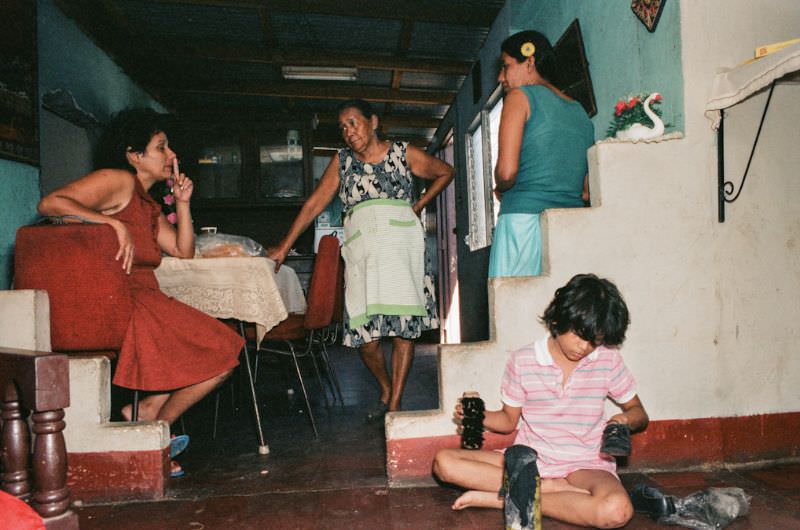 Angela, Doña Mercedes' daughter, sits with her two children holding the FSLN flag, Managua, Nicaragua, 1985