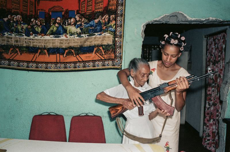Milena Montano helps her great aunt, La Conchita, pose with the AK47, Managua, Nicaragua, 1985