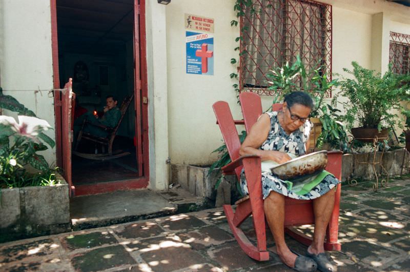 Doña Mercedes cleaning rocks from beans in front of the Montano home, Managua, Nicaragua, 1985