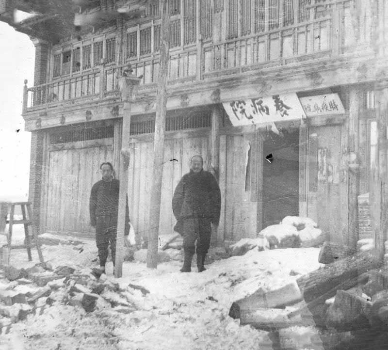 Dr. Ku and assistant in front of 'old style' Chinese plague hospital, Fuchiatien