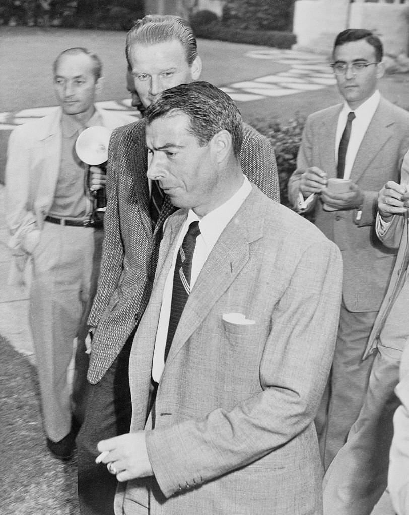 Joe DiMaggio strides past newsmen as he leaves the Beverly Hills honeymoon home he shared with film star Marilyn Monroe.