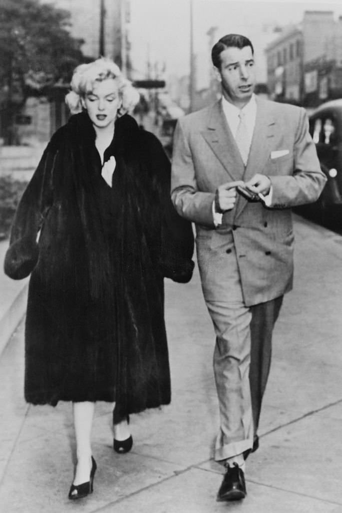 Joe DiMaggio and Marilyn Monroe walk in the street in 1954.