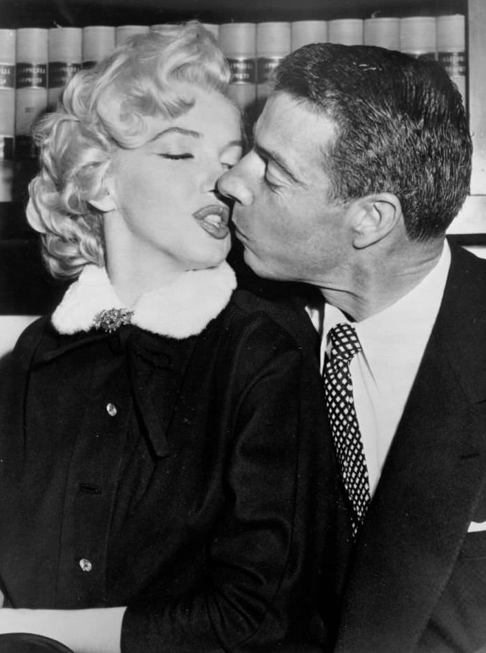 Marilyn Monroe kisses baseball player Joe Dimaggio during their short marriage in 1954.