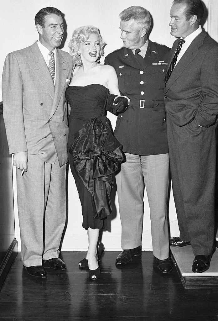 Joe DiMaggio and Marilyn Monroe are guests at an informal reception given by comedian Bob Hope (right) to honor two-star General William F. Dean December 16.