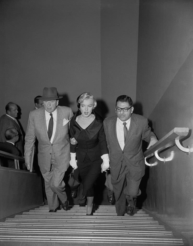 Attorney Jerry Giesler is shown escorting actress Marilyn Monroe into Superior Court where she obtained a divorce from Joe DiMaggio on grounds of "mental cruelty
