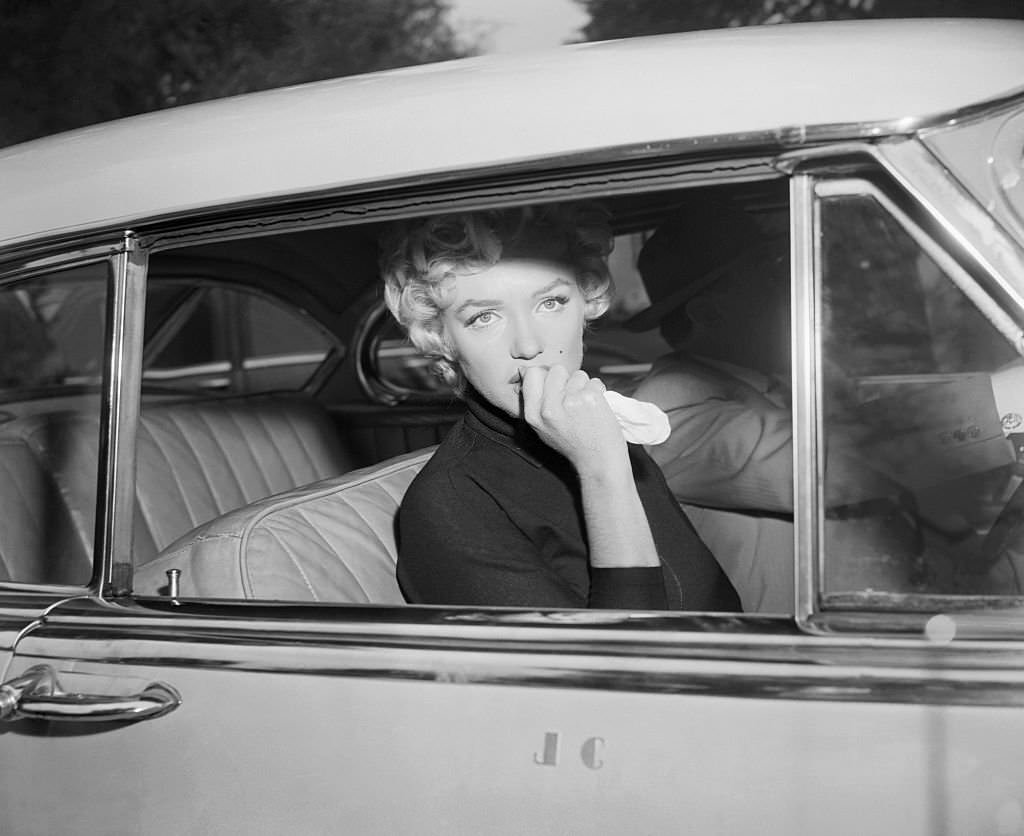 Marilyn Monroe leaves the home she briefly shared with Joe Di Maggio in a car driven by her attorney, Jerry Giesler.