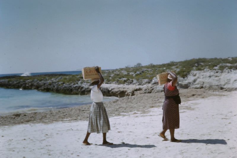 Women clearing seaweed on Paradise Beach, Nassau, 1960