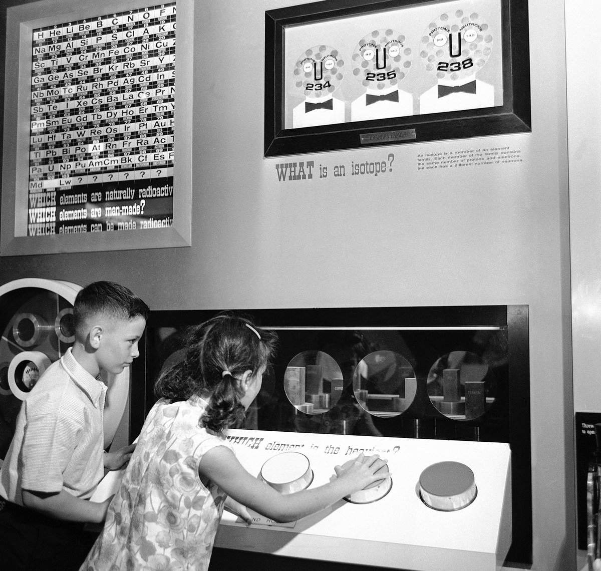 One many displays designed to brief youngsters on the fundamentals of atomic energy at the Atomic Energy Commission's "Atomsville, U.S.A.", this one demonstrates relative weight.