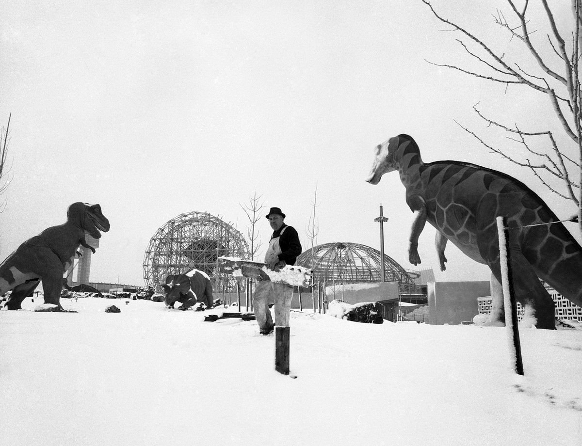 Carpenter Henry Johnson doesn't seem to concerned about his clutch of prehistoric companions at the Sinclair Oil Exhibit in the World's Fair grounds, New York City, February 19, 1964.