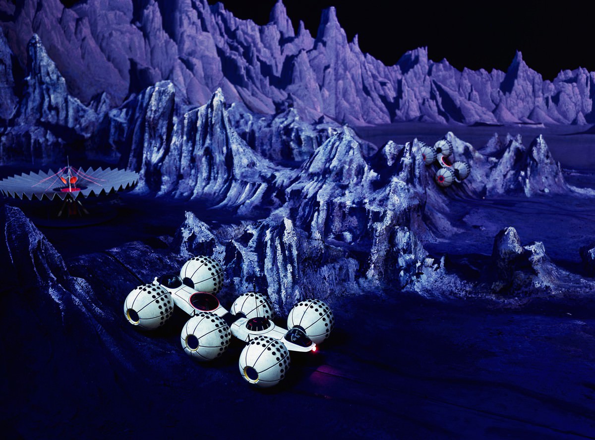 From the official guide book entry on Futurama: "A trip to the moon starts the ride taking the visitor past a scale model whose craters and canyons are dotted with manned 'lunar-crawlers' and commuter space ships."