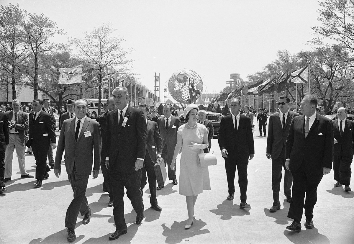 President Lyndon B. Johnson is flanked by Lady Bird Johnson and Norman K. Winston, as he walks through the New York World's Fair grounds, May 9, 1964.