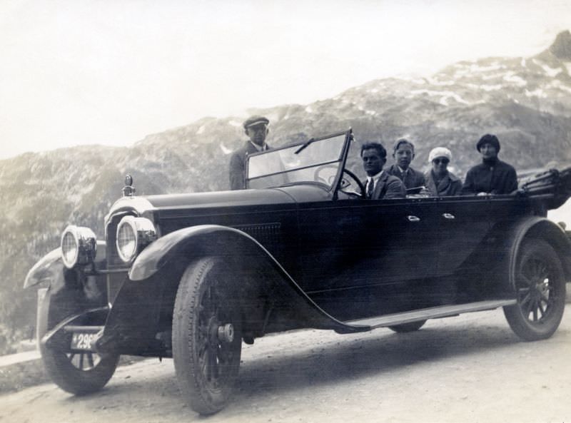 A company of five posing in a 1926 open-top Packard Phaeton on a graveled Alpine road, August 1927
