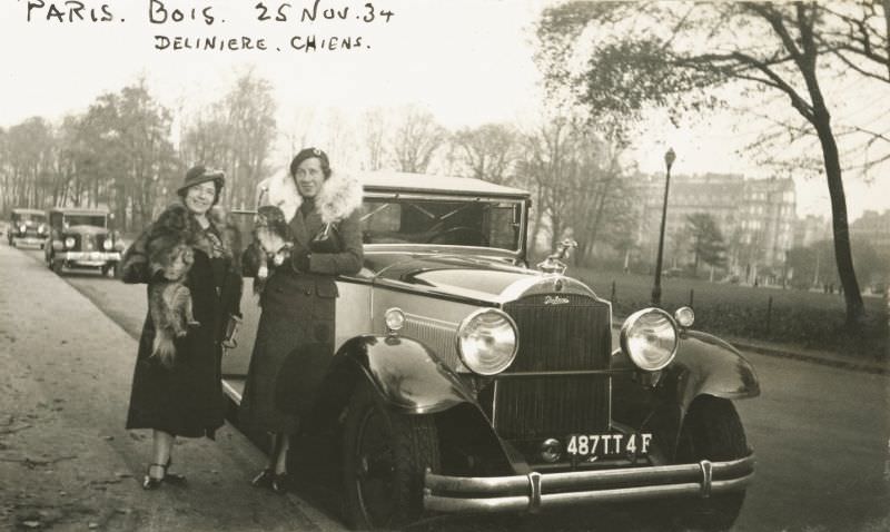 Two well-to-do Parisian ladies in fur-collared coats posing with their dogs and a 1930 Packard Standard Eight Convertible Coupe, November 25, 1934