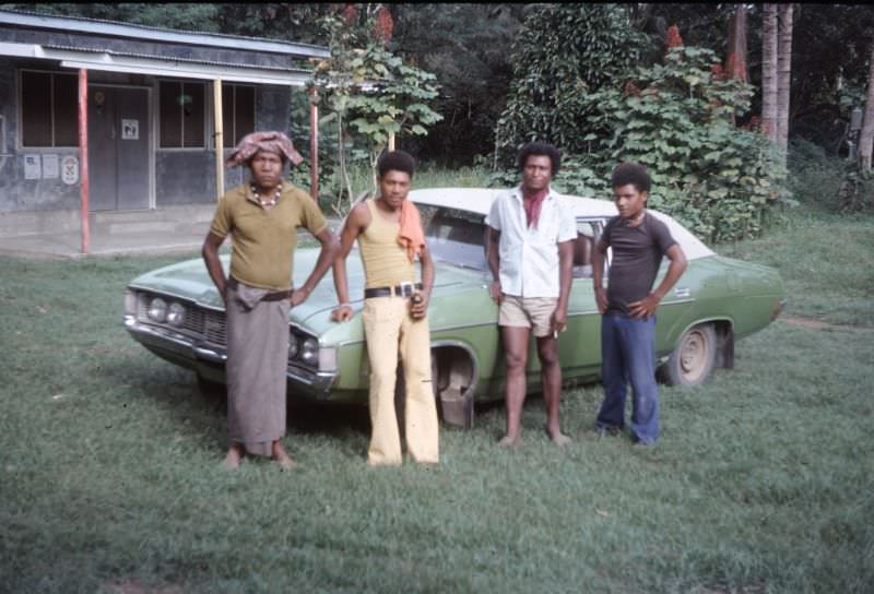 Papuans from village near Kwikila and Ford Fairlane outside tradestore, 1975