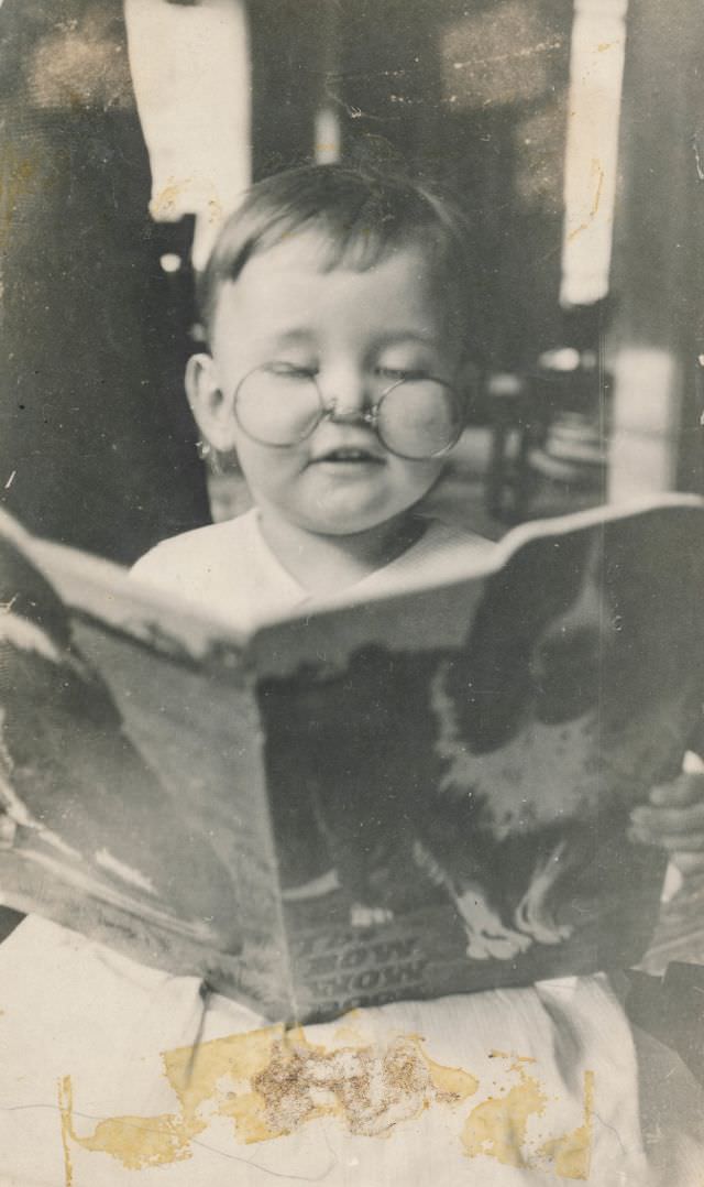 Little boy with spectacles reading "The Bow Wow Book", January 1924