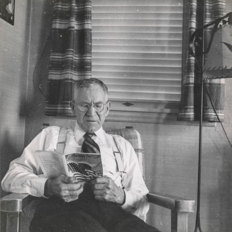 Elderly man reads "Readers Digest" in the living room, 1943