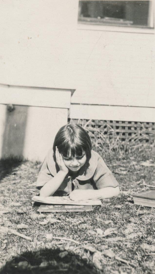 Little girl reading a book outside