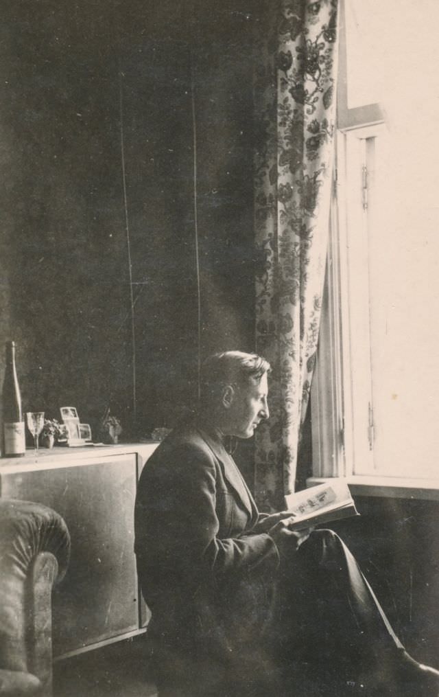 Man reading a book by the window