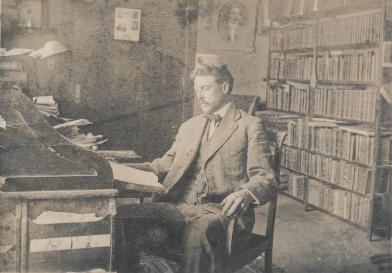 Man sits in his library, June 29, 1912