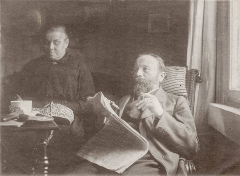 Man smokes a cigar and reads the paper, circa 1915