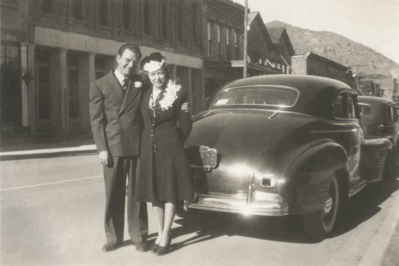 A man in a double-breasted suit and a lady with a fancy hat posing with a 1941 Pontiac Business Coupe.