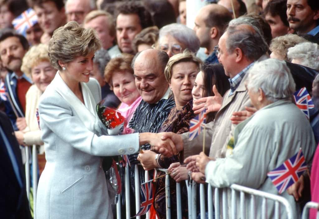 Diana, Princess of Wales, shakes hands with a well-wisher as she visits Wenceslas Square on May 6, 1991 in Prague.