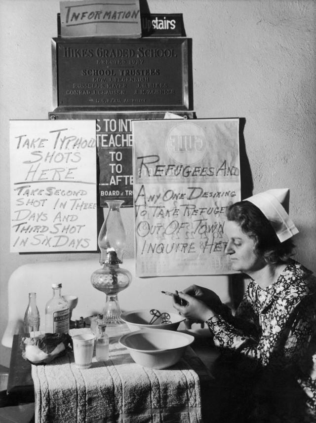 Nurse Clara Stull prepares typhoid inoculations for flood victims at an aid station in a Louisville, Kentucky, grade school, 1937.