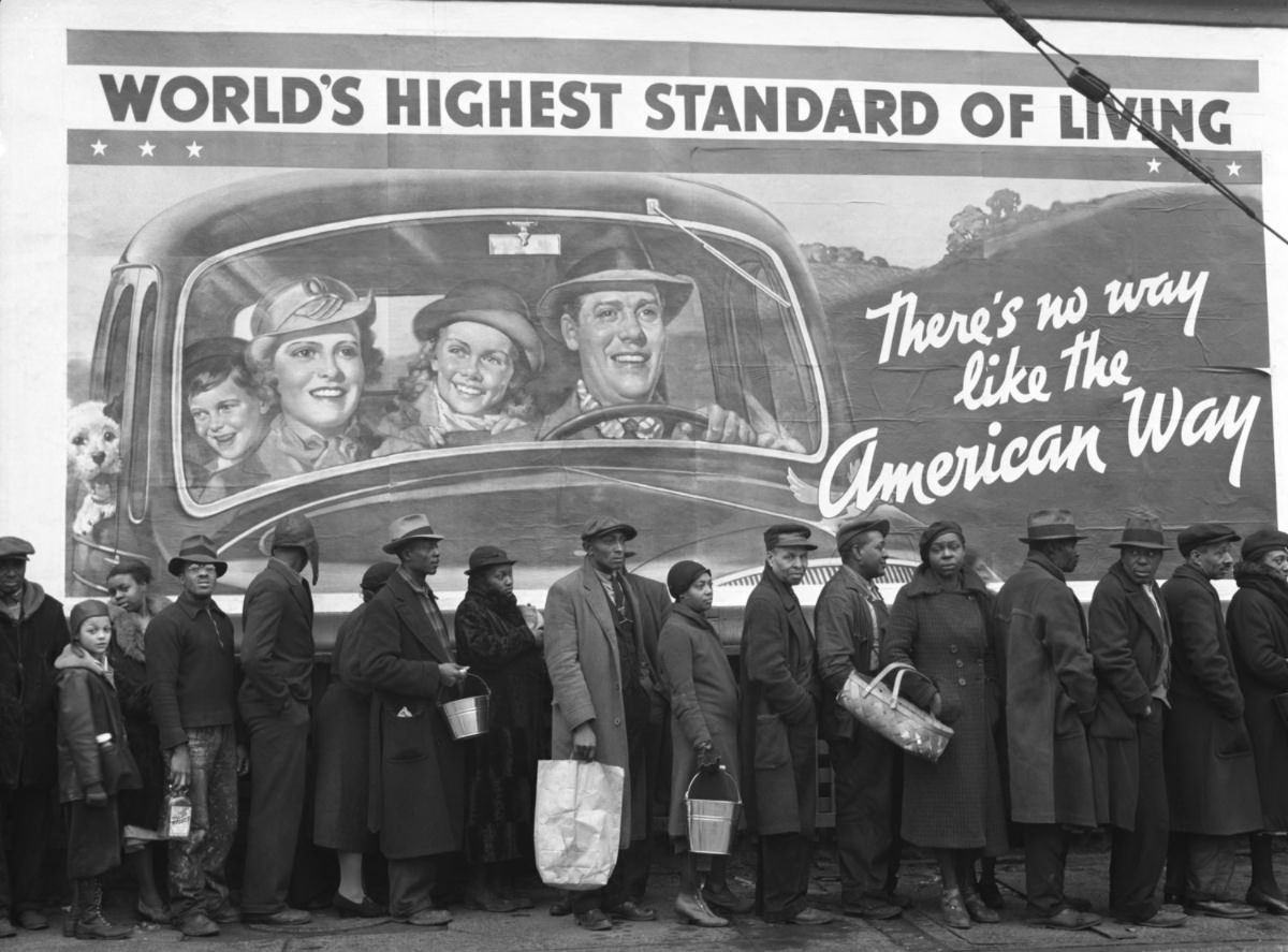 During the Great Ohio River Flood of 1937, men and women in Louisville, Kentucky, line up seeking food and clothing from a relief station.