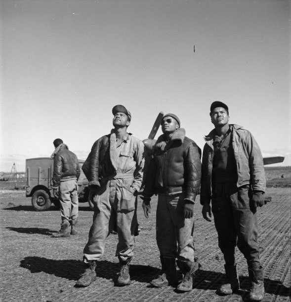 Three Tuskegee airmen looking skyward