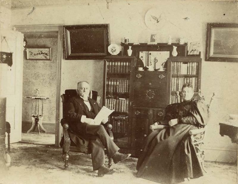 Man and woman seated in front of bookcase