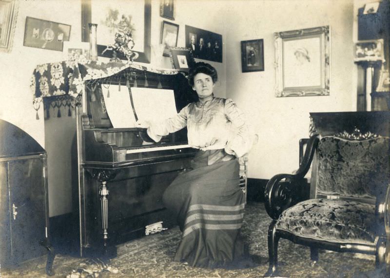 Woman seated at piano in living room