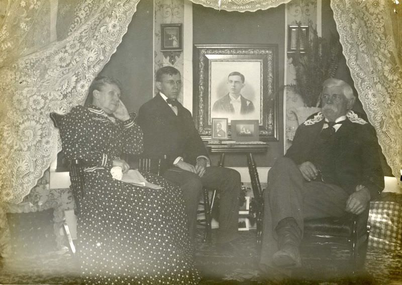 Family seated in front of lace curtain