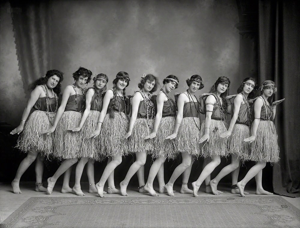 Young women (music hall dancers) in costume, standing barefoot in dance pose, wearing headbands, Nelson District, New Zealand, 1920