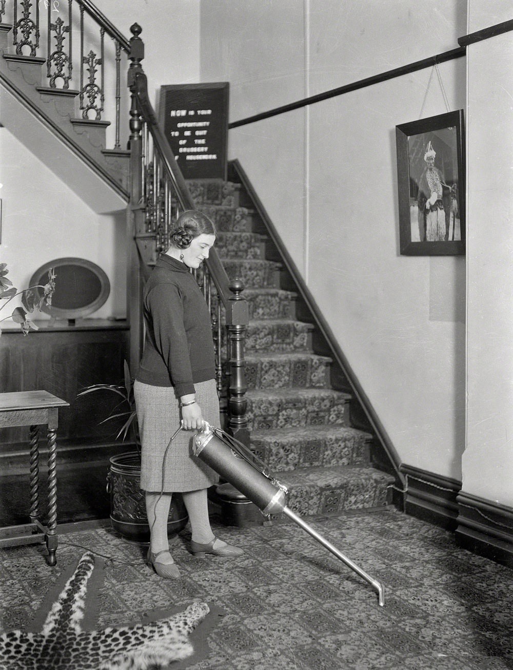 Woman using a vacuum cleaner in a hallway, Wellington, New Zealand