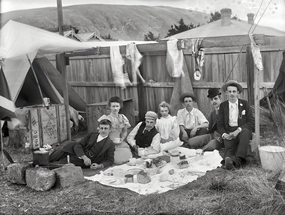 Unidentified group having a picnic outside tent in backyard of house, Christchurch district, New Zealand circa 1905