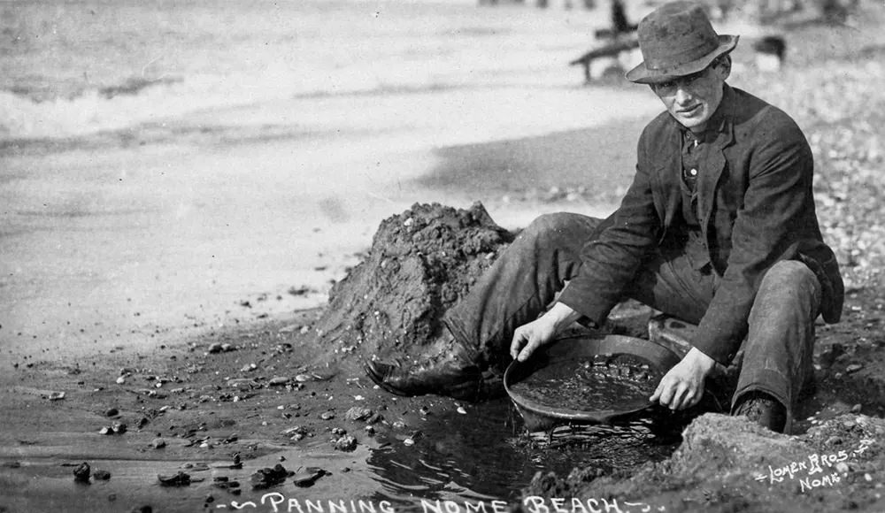 A man panning for gold on Nome beach.