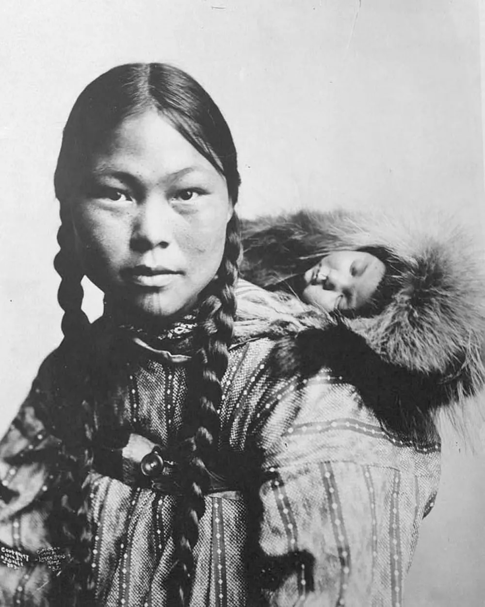 Eskimo mother with child on back.