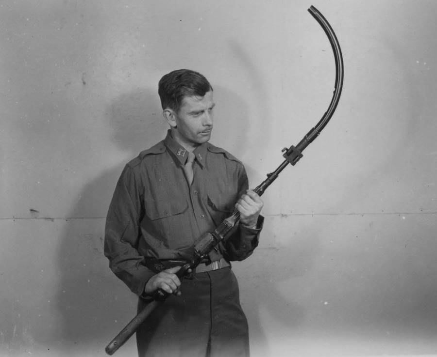A man holds a Krummlauf, an experimental curved rifle barrel attachment developed by the Nazis during World War II in order to shoot around walls and over barriers.