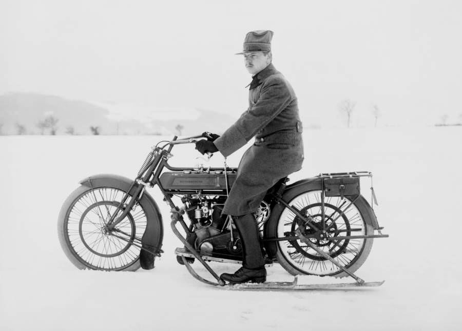 A man poses with a motorcycle equipped with skis in order to travel through the snow in Kehrsatz, Switzerland during World War I.
