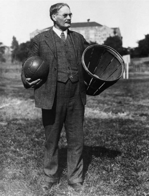 James Naismith, the inventor of basketball, holds an early ball and basket used for the game at an unspecified date sometime prior to 1939.