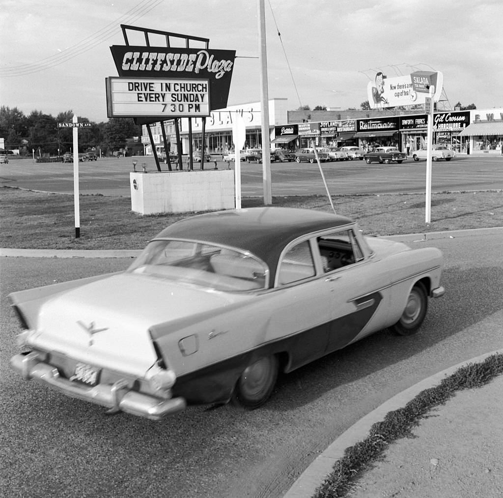 A car entering a Candian shopping mall's car park for a drive-in church service in Scarborough, 1955