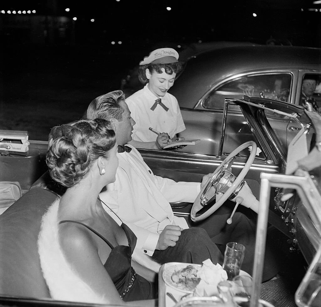 A young couple in a convertible order food at Tiny Naylor's Drive-In Restaurant in Los Angeles, 1951