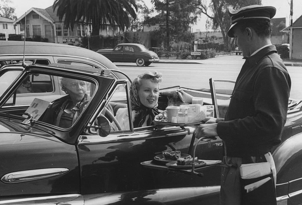 To Go.A waiter serves food to motorists at a drive-in restaurant in the Hollywood district of Los Angeles, 1951
