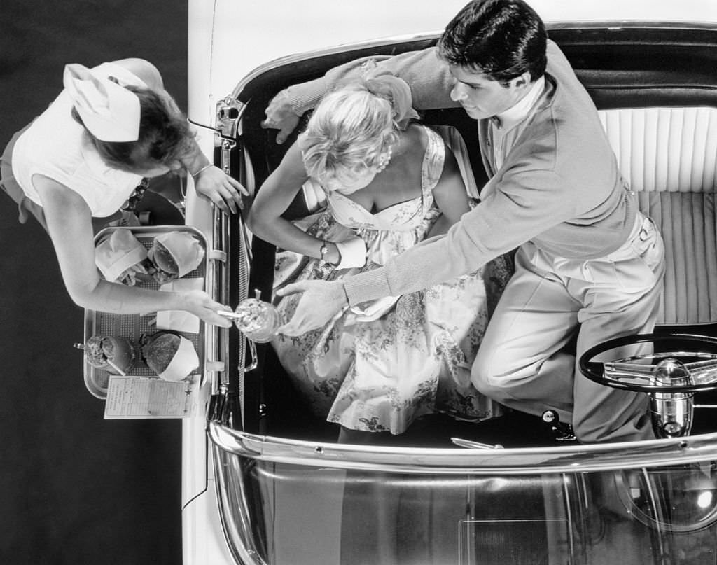 Carhop Waitress on roller skates serving couple, 1955