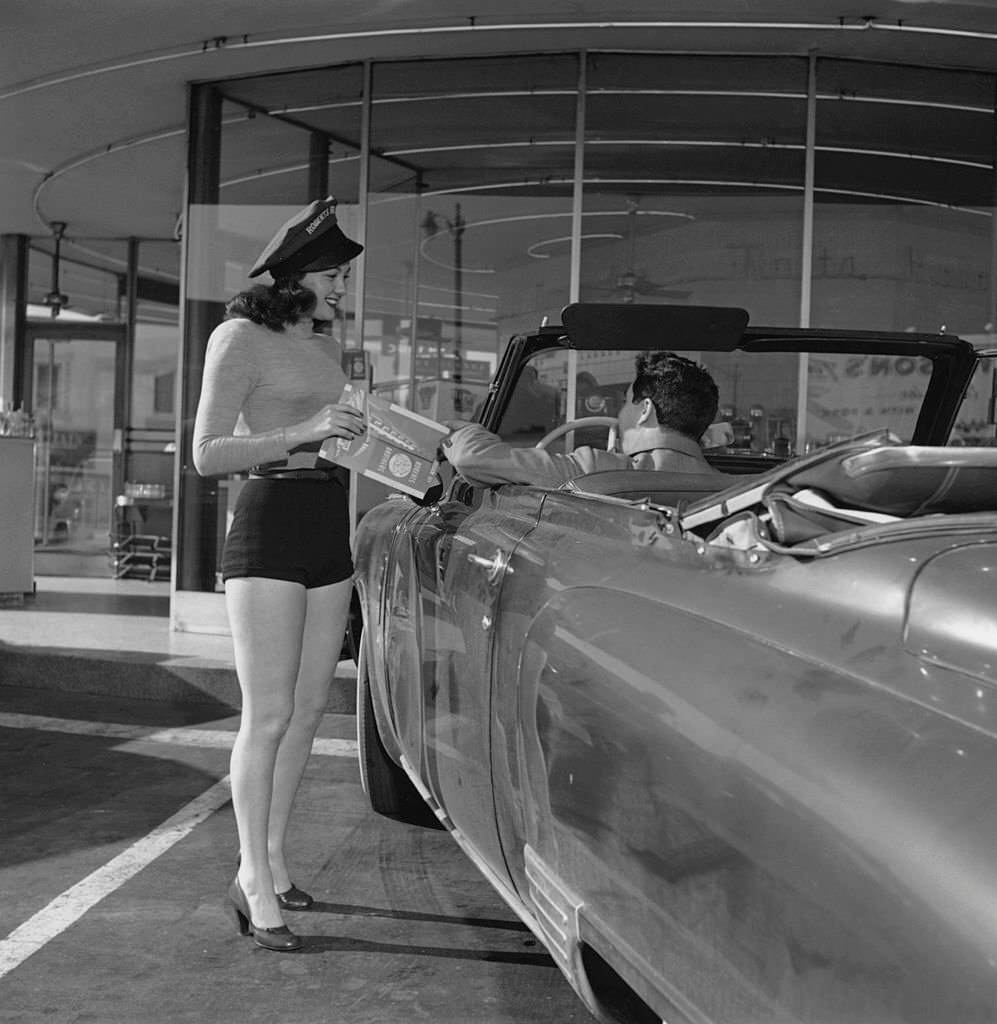 A waitress in shorts takes an order from a customer at a Roberts Brothers drive-in restaurant, 1958.