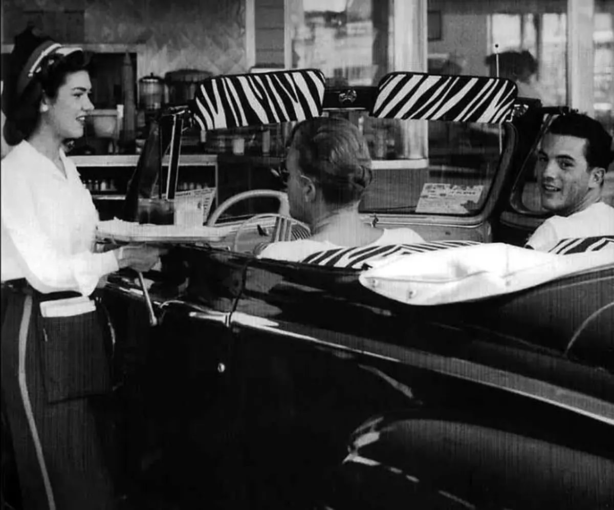 A friendly carhop converses with two guys in a ’46-7 Mercury convertible, at Simon’s Drive-In, 1948.