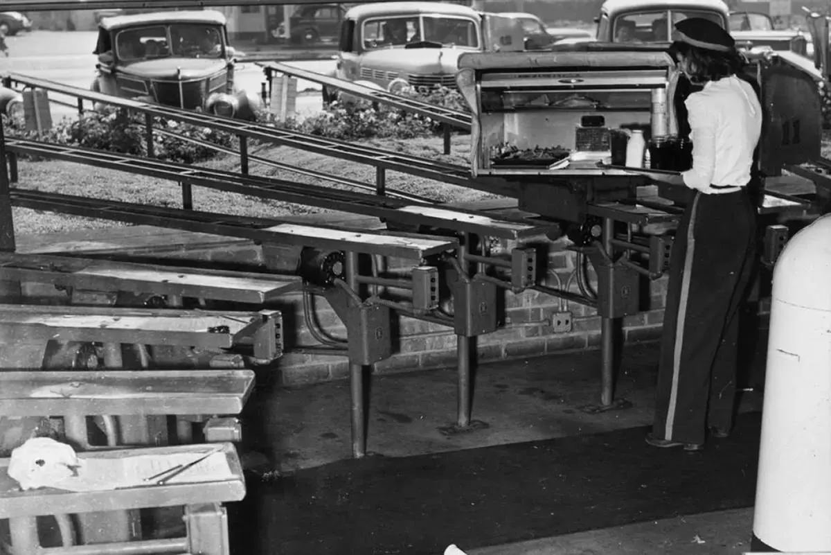 An employee loads the conveyor belts with meals for hungry customers.