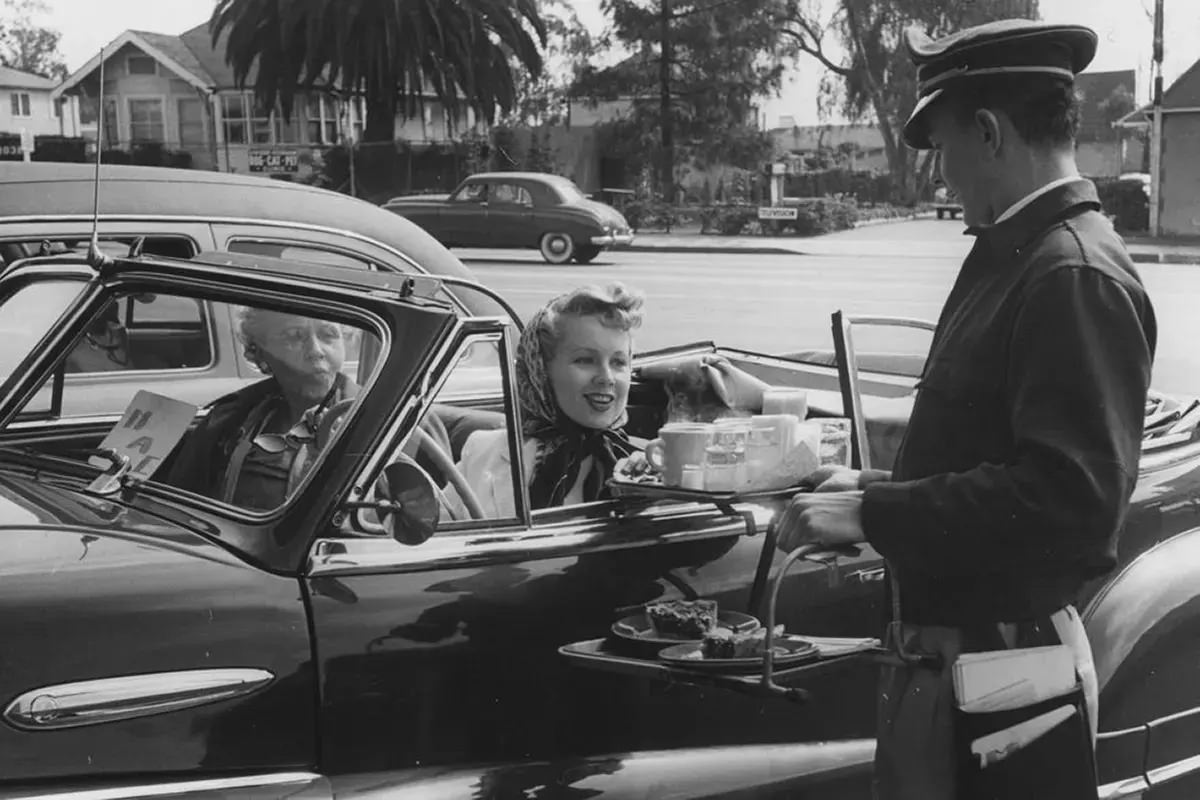 Drive-ins didn’t only serve burgers and fries. Depending on where you went, you could get a full dinner or just a steaming coffee in a mug. 1950s.