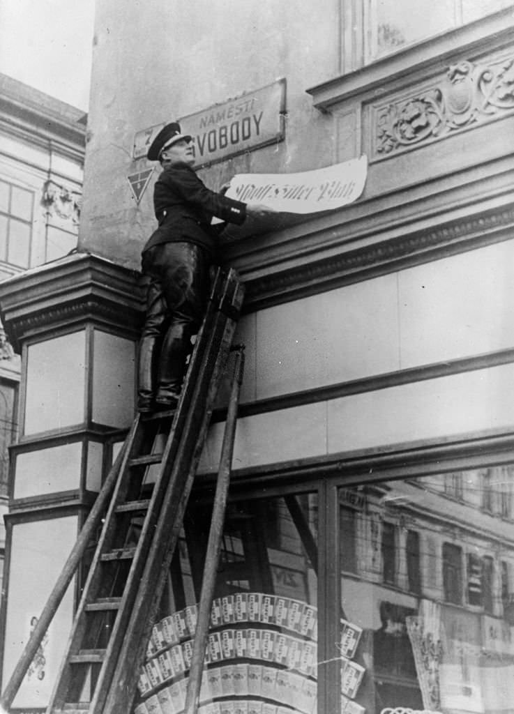 A jack booted official changing the name of a street in Brunn, Czechoslovakia, to 'Adolf Hitler Platz' after the German invasion.