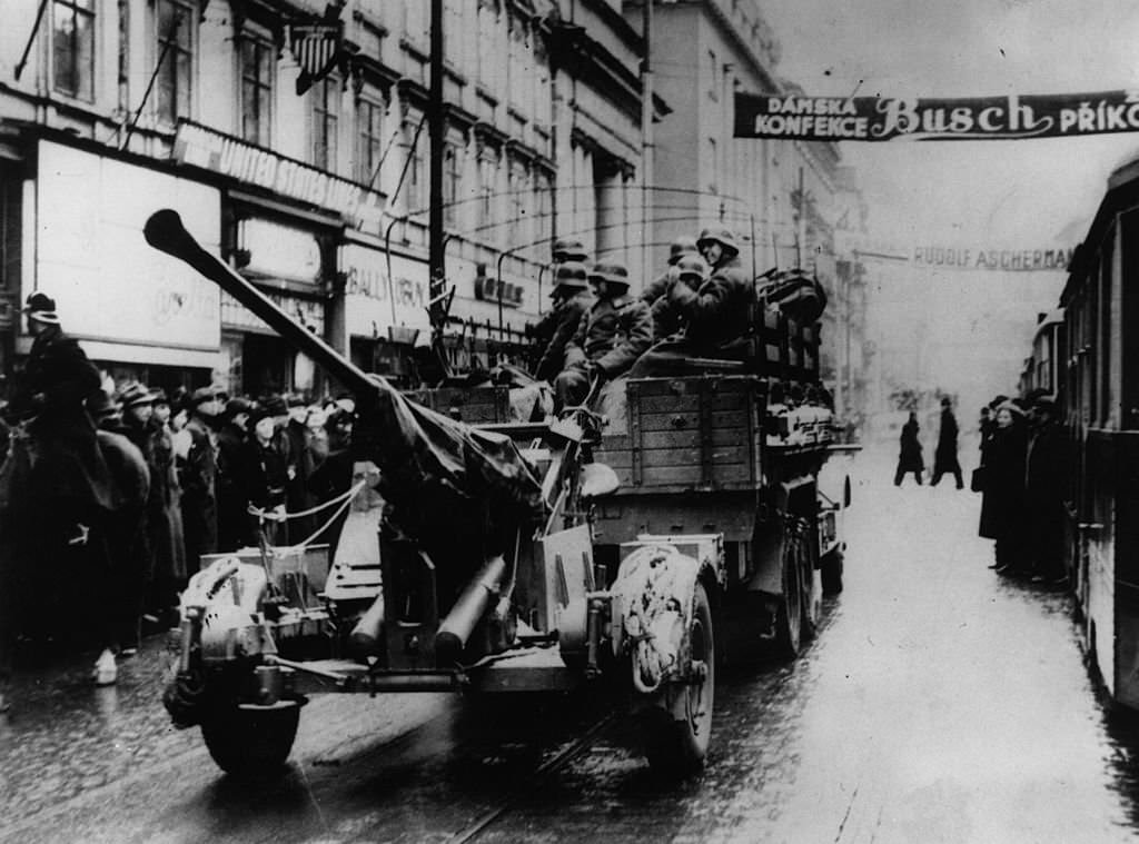 German troops entering Prague by lorry, towing anti-aircraft guns.
